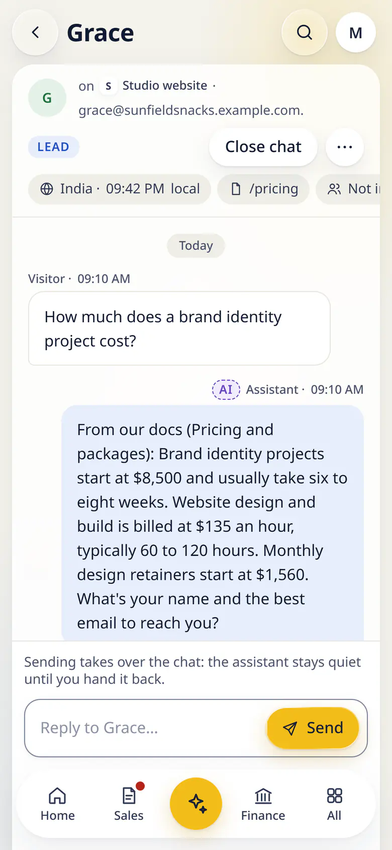 Chats in LuckPanda for Fernhill Studio on a phone: a visitor chat opened in the Chats inbox: the visitor asks what a brand identity project costs, the assistant answers from the Studio website project's pricing notes and asks for contact details, the visitor (Grace from Sunfield Snacks) leaves an email, and chips above the transcript show the page the chat started on and that she is not in the CRM yet, with the reply box below.