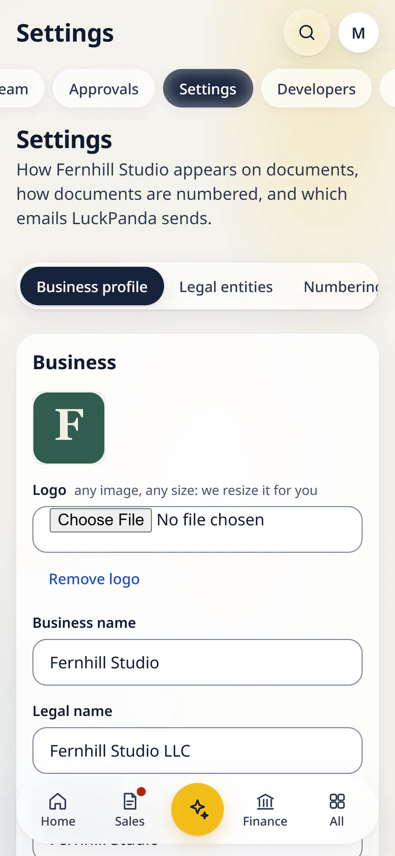 Settings in LuckPanda for Fernhill Studio on a phone: the business profile form of Fernhill Studio: logo, business and legal name, tax ID, other registrations, address and contact, with tabs for numbering and notifications.